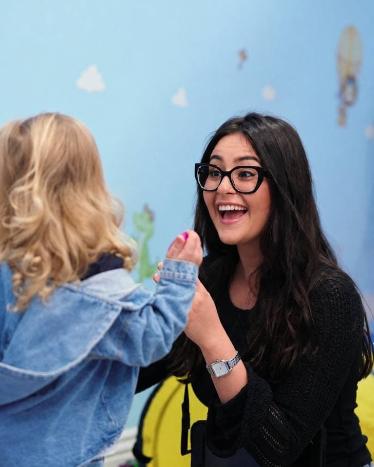 A Sunny therapist smiling with a child during a one-on-one session