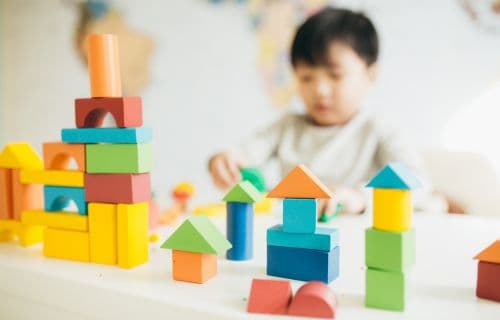 Child playing with blocks A child playing with colorful wooden blocks on a table